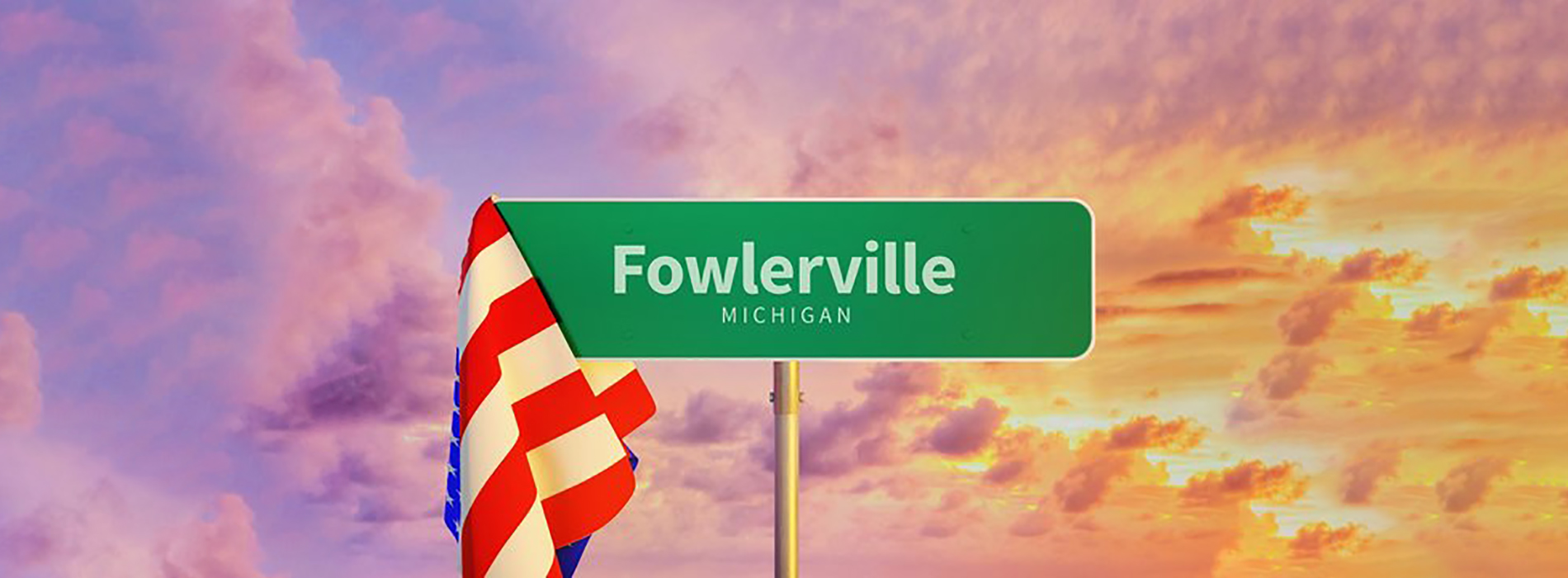 The image shows a street sign for Fowlerville, with the American flag in the background.