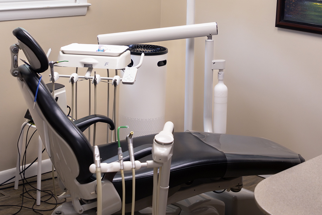 Dental chair with adjustable headrest and footrests, set up for dental procedures.