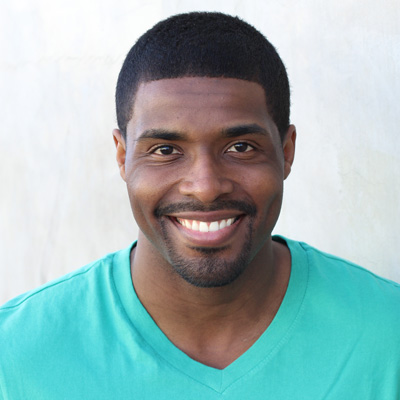 An elderly couple sharing a warm embrace, with the man smiling and the woman laughing.