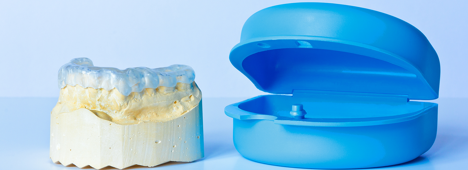 This image shows a blue dental implant on the right side and a yellow dental crown on the left, both against a white background.