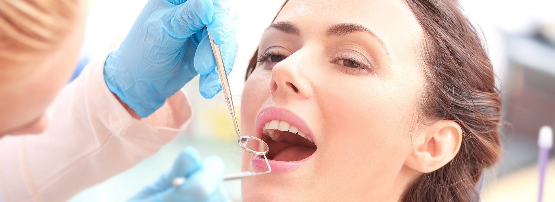 A dental professional administering dental care to a patient in a clinical setting.